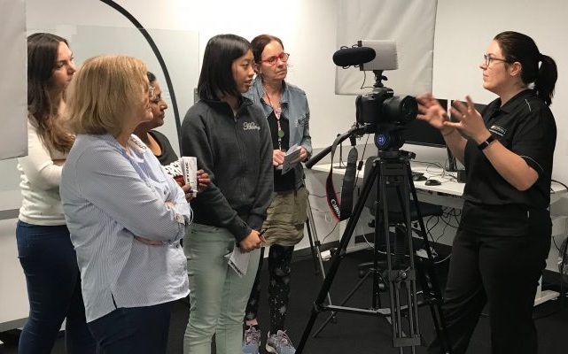 a group of people being instructed on filming